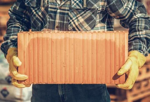 Building Ceramic Block in Hands of Construction Worker. Stock Photos