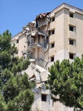Building collapse shows damage and structure failure in city under clear bl.. Stock Photos