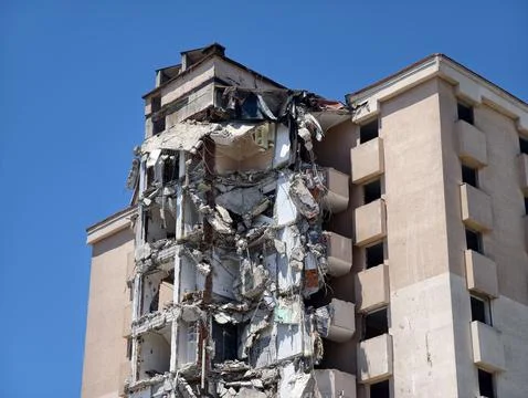 Building collapse in urban area during clear weather under bright sky Stock Photos
