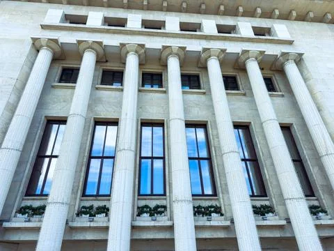 Building with columns and windows in a public area during the day with blue.. Stock Photos