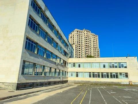 Building complex with new and old architecture under clear blue sky Stock Photos