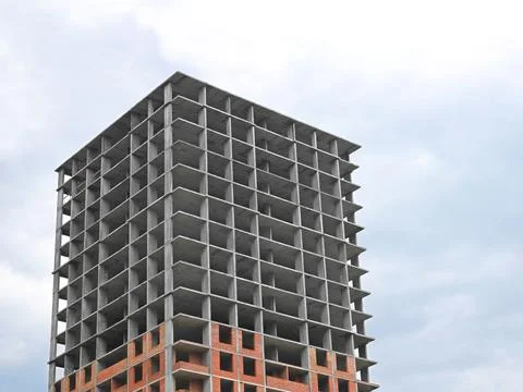 Building construction on the background of light cloudy sky Stock Photos