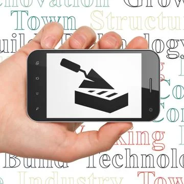 Building construction concept: Hand Holding Smartphone with Brick Wall on Ilustración de archivo