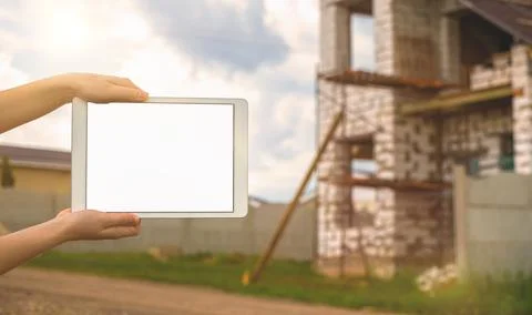Building construction mockup, tablet with black white screen in hand on backg Fotos de archivo