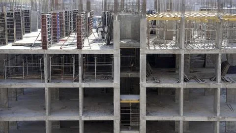 Building construction progress: workers installing concrete floor slab. Stock Photos