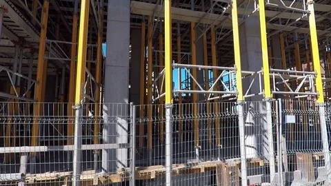 Building construction site ground level viewed through metal fence, barricade Stock Footage 99425876