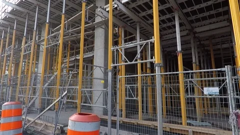 Building construction site ground level viewed through metal fence, barricade Stock Footage 99425902