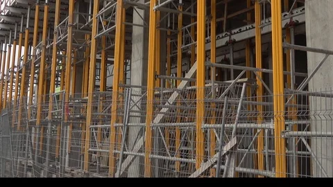 Building construction site ground level viewed through metal fence, barricade Video stock 99425948