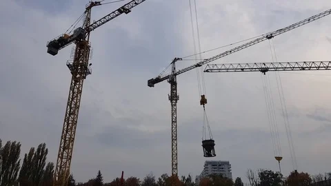 Building construction, three cranes lifting and moving large and heavy objects Stock Footage 81630838