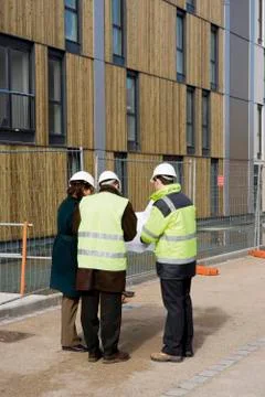 Building contractor and architects in discussion at construction site Stock Photos