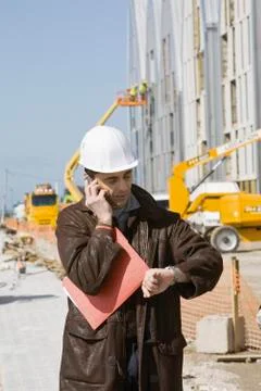 Building contractor using cell phone, checking time Fotos de archivo