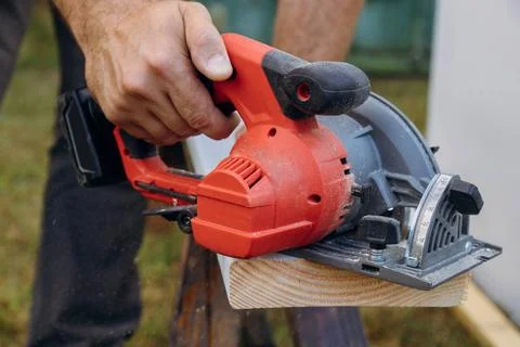 Building contractor worker using hand circular saw to cut boards on a new... Stock Photos