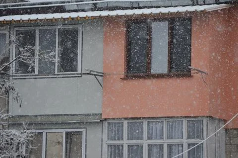 A building covered in snow with a window on the side.  Stock Photos