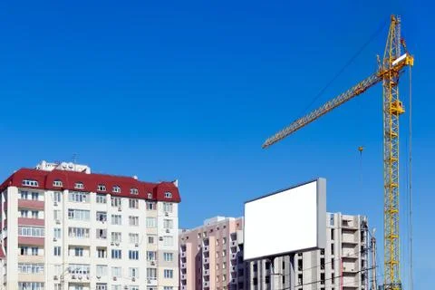 Building crane against the background of a multi-storey building. Stock Photos