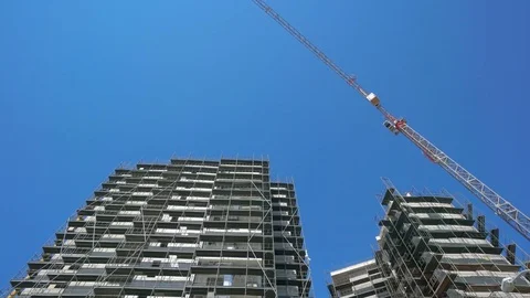 Building crane and building under construction against blue sky Stock Footage 76961398