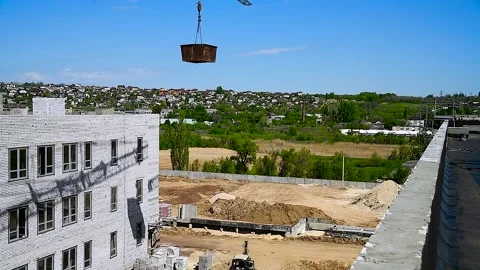 Building crane and building under construction against blue sky Stock Footage 305988563
