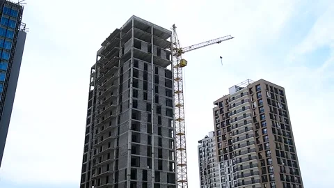 Building crane and building under construction against blue sky Stock Footage 305988809