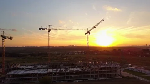 Building cranes at construction site against sunset sky. Aerial shot Video stock 81412980