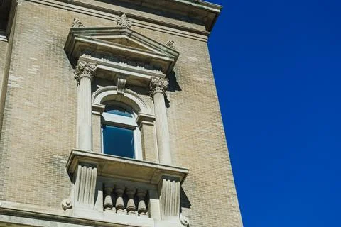 Building with a decorative window under a clear blue sky in a city setting .. Stock Photos