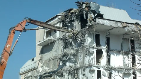 Building demolition by excavator with debris Stock Footage 105934525