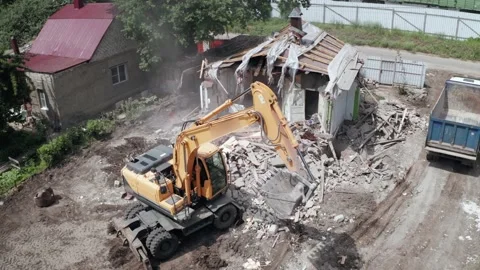Building demolition. Old broken house by hydraulic excavator Stock Footage 157239337