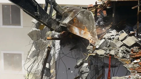 Building demolition. Slow Mo. Using an excavator to demolish a multi flat house Stock Footage 88475650