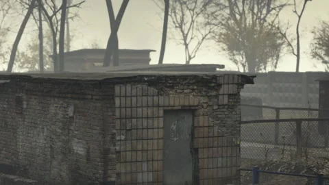 Building in a desolate area with trees and fog in the background Video stock 344398873