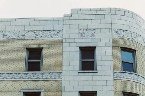 Building with detailed stonework on the upper levels and windows visible ag.. Stock Photos