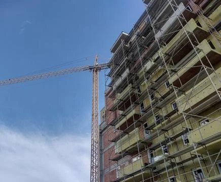 A building during construction and a crane next to it. Construction concept; Stock-Fotos