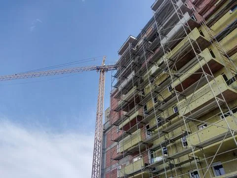 A building during construction and a crane next to it. Construction concept; Fotos de archivo