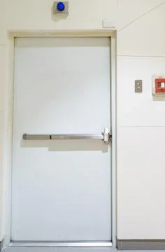 Building emergency exit with exit sign on door and fire extinguisher on the.. Stock Photos