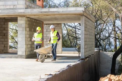 Building engineer and mason during a construction site visit Stock Photos