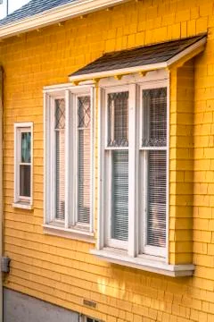 Building exterior with yellow wall cladding and awning over the window Fotos Stock