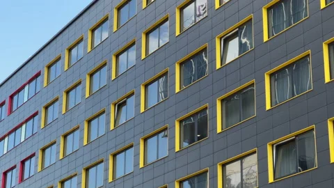 Building facade with black aluminum cladding and yellow and red window slopes Stock Footage 196953898