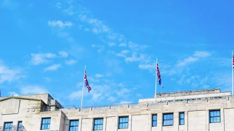 Building facade with British flags against a clear blue sky Stock Photos