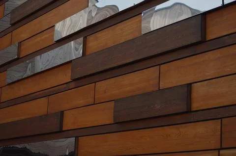 Building facade cladding. Decorative rectangular brown wood and mirror pane.. Fotos de archivo