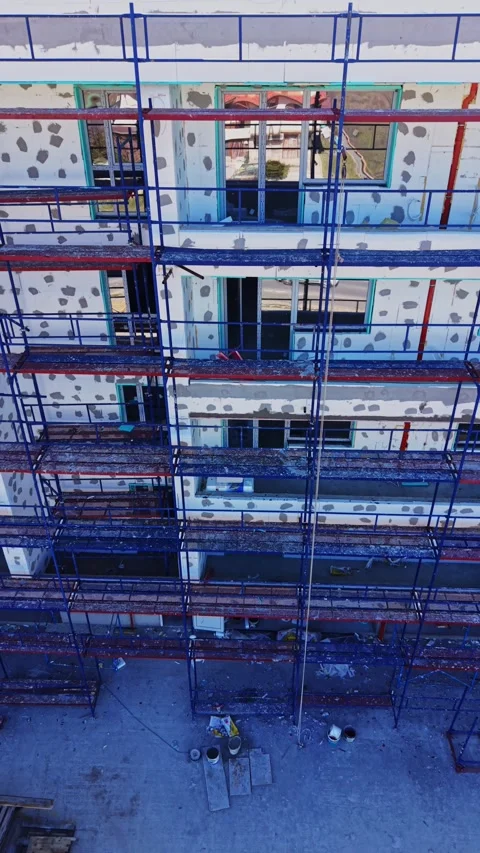 Building facade covered with insulation and scaffolding Stock Footage 338187688