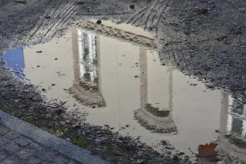 Building facade reflection in a muddy puddle on the street 写真素材