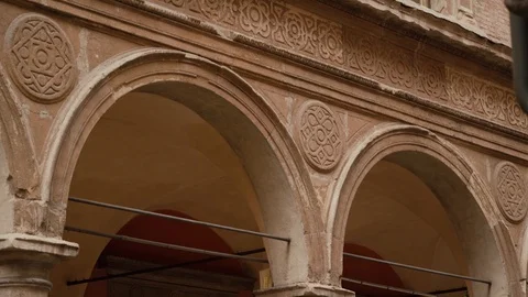 Building facade with stone columns, arches, decorative stucco elements, windows Stock Footage 125607616