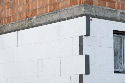 Building facade under construction is covered with insulation panels. The t.. Stock Photos