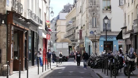 Building facades with shops and people walking the streets of the Latin Quarter Stock Footage