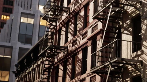 Building with fire escapes in an urban setting during evening hours Stock Footage 344304730