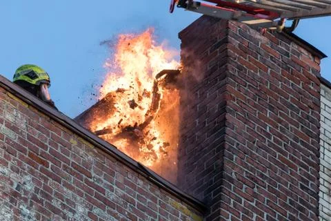 Building on fire with flame around chimney Stock Photos