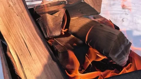Building a fire with logs in a grill on a snowy day in winter Stock Footage 329883754