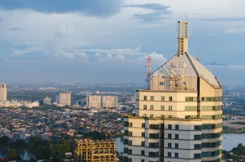 A building in focus with a mountain background covered in smog during sunset Stock Photos
