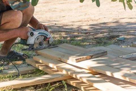 Building a formwork for the fence. Carpenter using a circular saw to cut a wo Foto stock