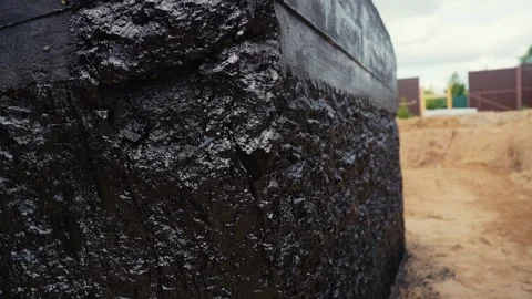 Building foundation waterproofing with bitumen mastic Stock Footage 341294498