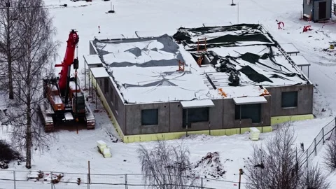 Building frame with snow and crane on active development site in winter Video stock 330897422