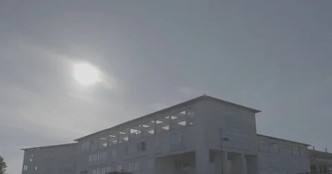 Building in front of the sun breaking through the clouds 스톡 동영상 78026020