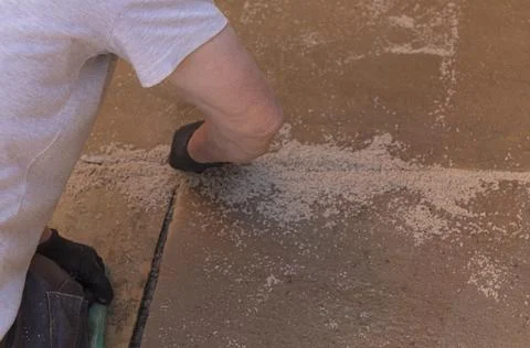 Building grouting the cracks in some paving Stock Photos